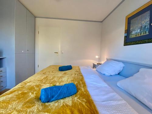 a bedroom with a bed with two blue pillows on it at Idyllisches Ansbacher Apartment 1 Stock mit Aufzug in Ansbach