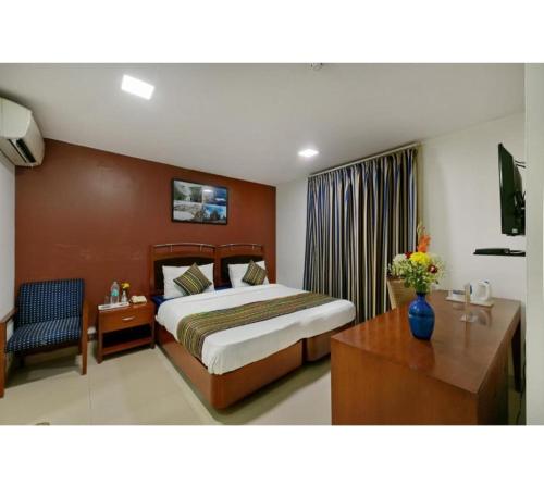 una camera d'albergo con letto e scrivania di Golden Dream a Nuova Delhi