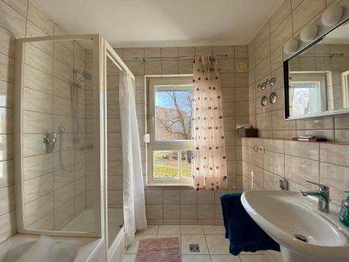 La salle de bains est pourvue d'une douche, d'un lavabo et d'une baignoire. dans l'établissement Idyllisches Ansbacher Apartment 1 Stock mit Aufzug, à Ansbach