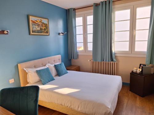 a bedroom with a large bed with blue walls at Hotel de Charme La Bonne Adresse - Logis hotels in Le Havre