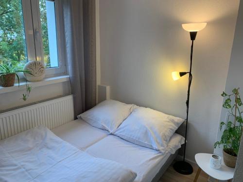a bed in a room with a lamp and a window at Widok Zamku o poranku in Malbork