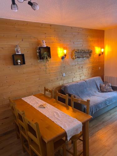 ein Esszimmer mit einem Tisch und einem Bett in der Unterkunft Chaleureux appartement grand panorama 2 avec piscine au pied des pistes in Valmeinier