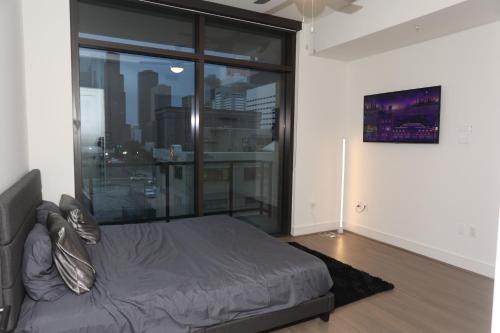a bedroom with a bed and a large window at Houston's Downtown Oasis in Houston
