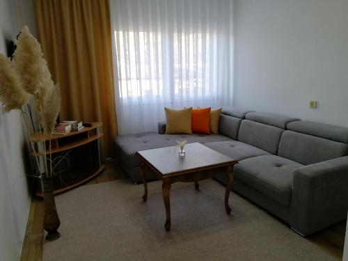 a living room with a couch and a coffee table at Apartman Mušinbegović in Visoko