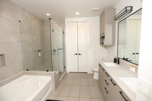 a white bathroom with a tub and a shower at Houston's Downtown Oasis in Houston