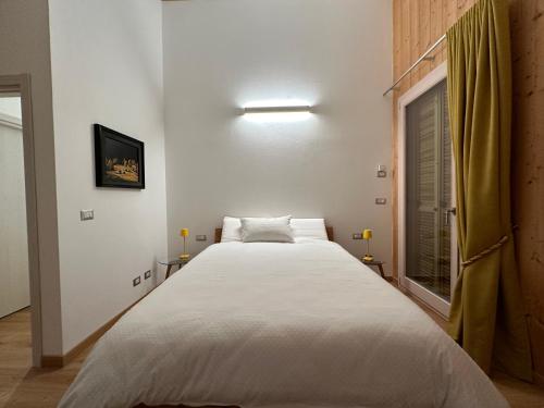 a large white bed in a room with a window at Nido di Laura in Santa Maria Maggiore