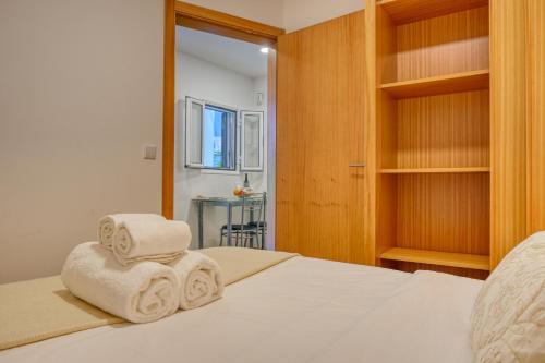 1 dormitorio con 1 cama y 2 toallas en Casa Familia Pestana 1, a Home in Madeira, en Seixal
