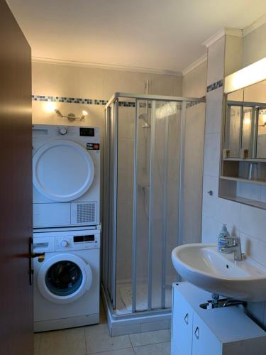 een badkamer met een wasmachine en een wastafel bij Schönblick23 in Langfurth 