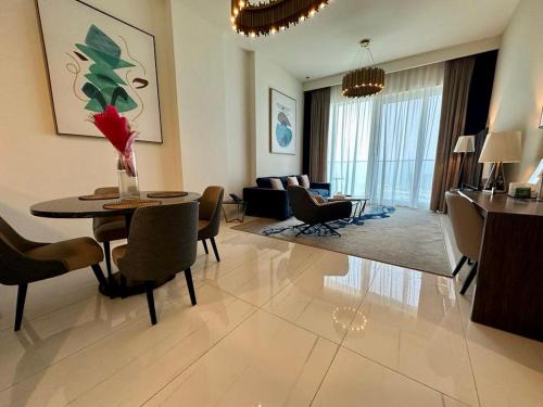 a living room with a table and chairs and a couch at Myhome Avani Palm View Dubai in Dubai