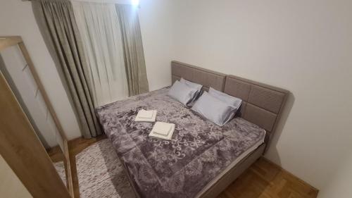a small bedroom with a bed with two books on it at Apartment Dimitrije in Budva