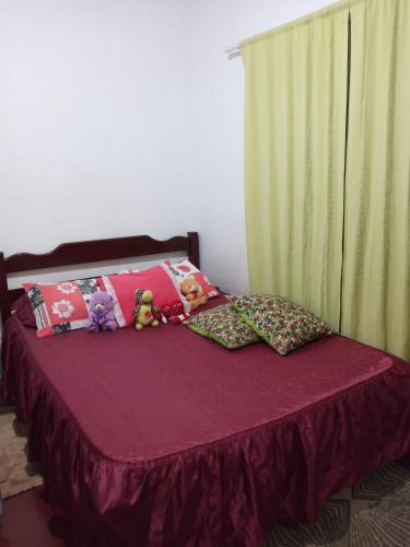 a purple bed with stuffed animals on top of it at Lazer Caraguatatauba ✓ in Caraguatatuba