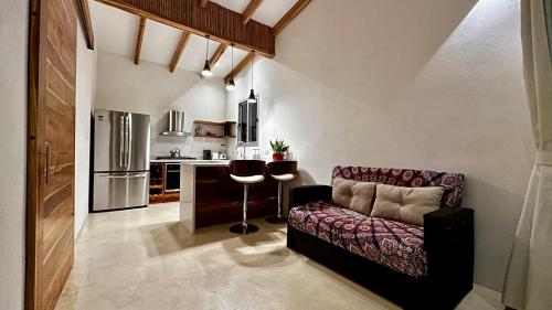 a living room with a couch and a kitchen at Villas Paraiso Azul in Santa Teresa Beach
