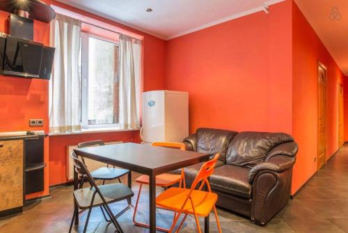 een woonkamer met een leren bank en een tafel bij Fancy private student's rooms in Rīga