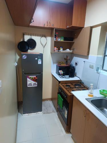 a small kitchen with a refrigerator and a sink at Angel Asenath 2Bedroom apartment in Nairobi
