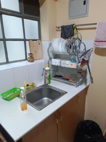 a kitchen sink with a dish rack above it at Angel Asenath 2Bedroom apartment in Nairobi