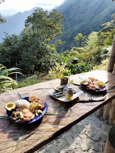 a wooden table with plates of food on it at Sierra de viboral adventures in Medellín