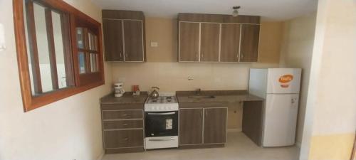 eine Küche mit Herd und Kühlschrank in der Unterkunft Dúplex Mar de Ajó in Mar de Ajó