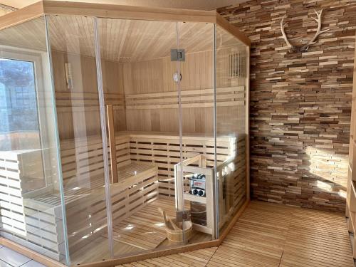 a glass shower in a room with a brick wall at Großzügige und romantische Wellnessoase mit privater Sauna in ruhiger Lage in Karlsbad