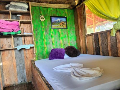 a room with a bed in a wooden house at Sierra de viboral adventures in Medellín