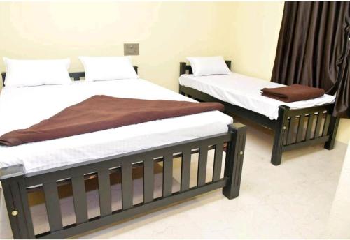 two beds sitting next to each other in a room at Pragathi Residency in Dharmastala