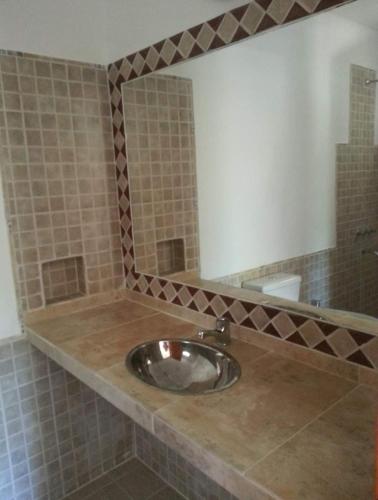 y baño con aseo y espejo. en Hostería Edelweis en Villa Gesell