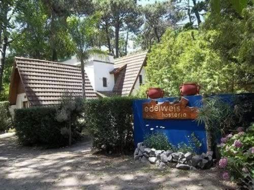 una casa con un cartel delante de un patio en Hosteria Edelweis en Villa Gesell