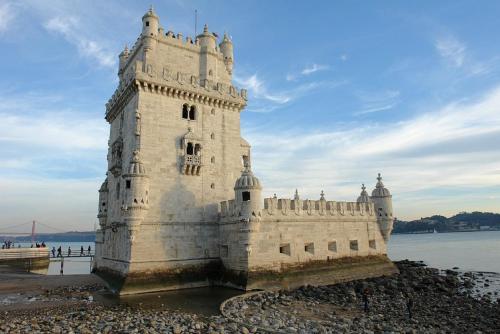 a white castle on the shore of a body of water at Hotel Jeronimos 8 in Lisbon