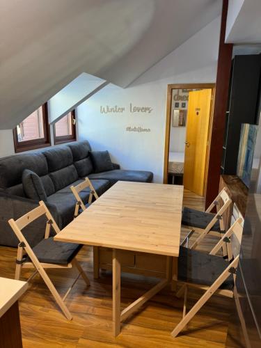 sala de estar con mesa de madera y sillas en Acogedor Ático en el Corazón de Formigal, en Formigal