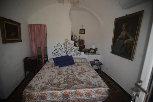 a bedroom with a bed and a painting on the wall at Agriturismo La Contessa in Finale Ligure