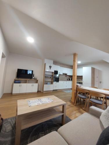 a living room with a table and a kitchen at Polanský Dvůr in Velké Karlovice