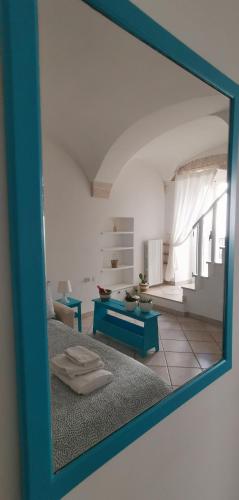 a mirror reflecting a living room with a blue table at MI PUGLIA Casa vacanze in Putignano