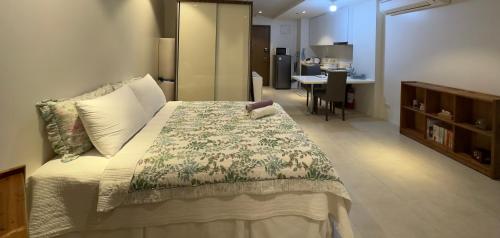 een slaapkamer met een groot bed en een eetkamer bij Ella's Studio in Maribago