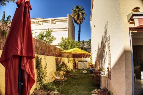 a yard with an umbrella and a fence at A1 LA PLAGE D'OR in Le Lavandou