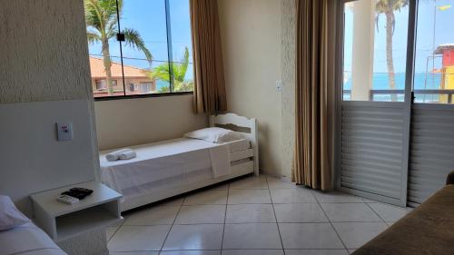een slaapkamer met een bed en een groot raam bij Pousada Sol e Mar Ingleses in Florianópolis