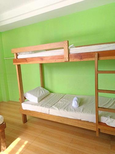 two bunk beds in a room with a green wall at Pangandoy Homestay in General Luna