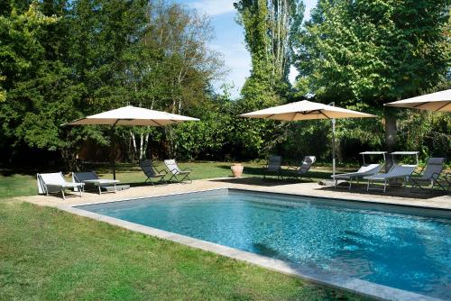 - une piscine avec deux parasols, des chaises et un sidx sidx sidx dans l'établissement Casale La Gora - B&B di charme, à Figline Valdarno