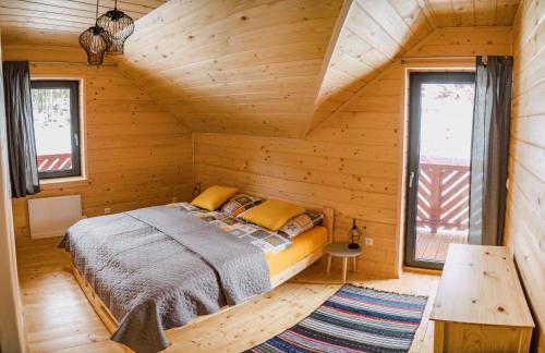 sypialnia z łóżkiem w drewnianym domku w obiekcie Chata Jazorna w Liptowskim Mikulaszu