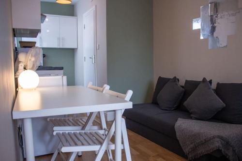 uma sala de estar com uma mesa branca e um sofá em Cosy apartment 7 mins walk from Wembley stadium em Londres