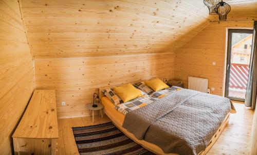 a bedroom with a bed in a wooden room at Chata Jazorna in Liptovský Mikuláš