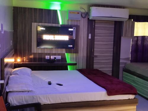 a bedroom with a bed and a tv on a wall at LN BEACH Homestay in Puri