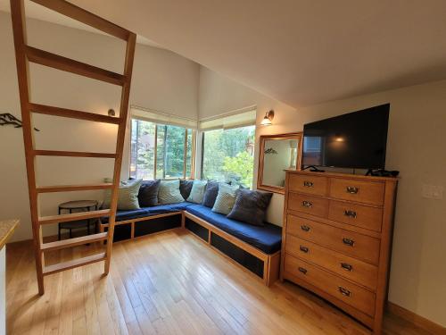 a living room with a blue couch in front of a window at Quiet Lofted Studio at Tomboy Lodge in Telluride