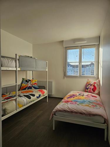 une chambre avec deux lits superposés et une fenêtre dans l'établissement Appart 3 chambres-Gare 1 min-Disneyland Paris 6 min, à Bussy-Saint-Georges