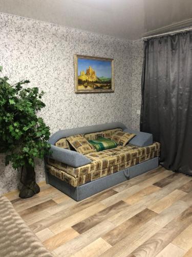 a bedroom with a bed with a painting on the wall at Квартира Пентагон in Korostenʼ
