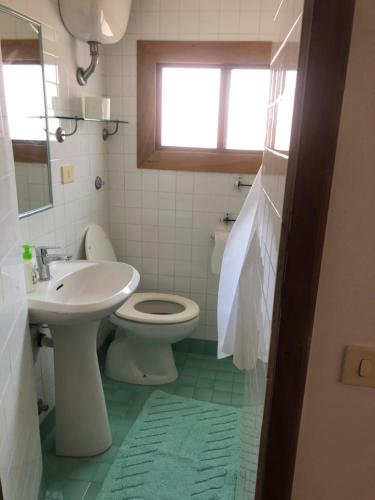 a bathroom with a sink and a toilet and a window at L'Orbetellana - Guest House in Orbetello