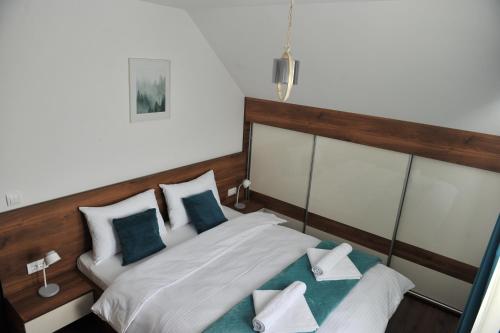 a bedroom with a bed with blue and white pillows at Ramondia, Kopaonik in Kopaonik