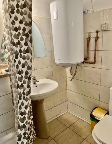 a small bathroom with a sink and a toilet at Ming with free parking in Braşov