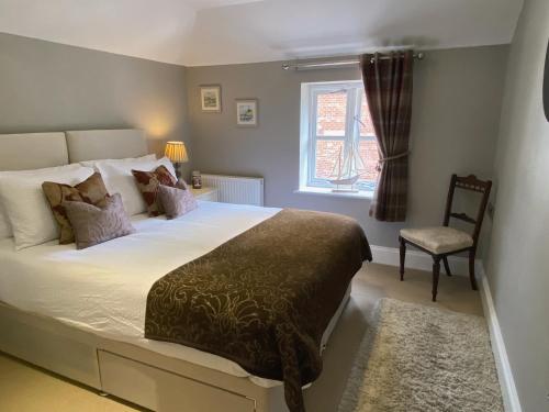 a bedroom with a bed and a chair and a window at Luxury Home With Stunning River Views in Knaresborough