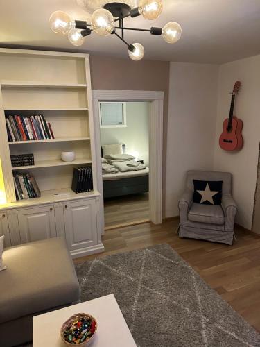 Sala de estar con dormitorio con cama y guitarra en Fin leilighet, sentralt og sjønært,med parkering en Arendal
