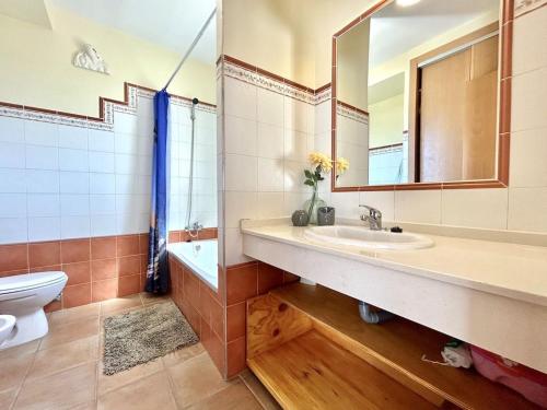 y baño con lavabo, aseo y espejo. en CASA TRINIDAD, en Huelva