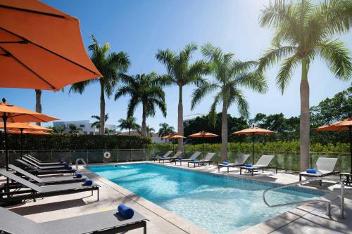 a swimming pool with chairs and umbrellas and palm trees at Four Points by Sheraton  in Punta Cana